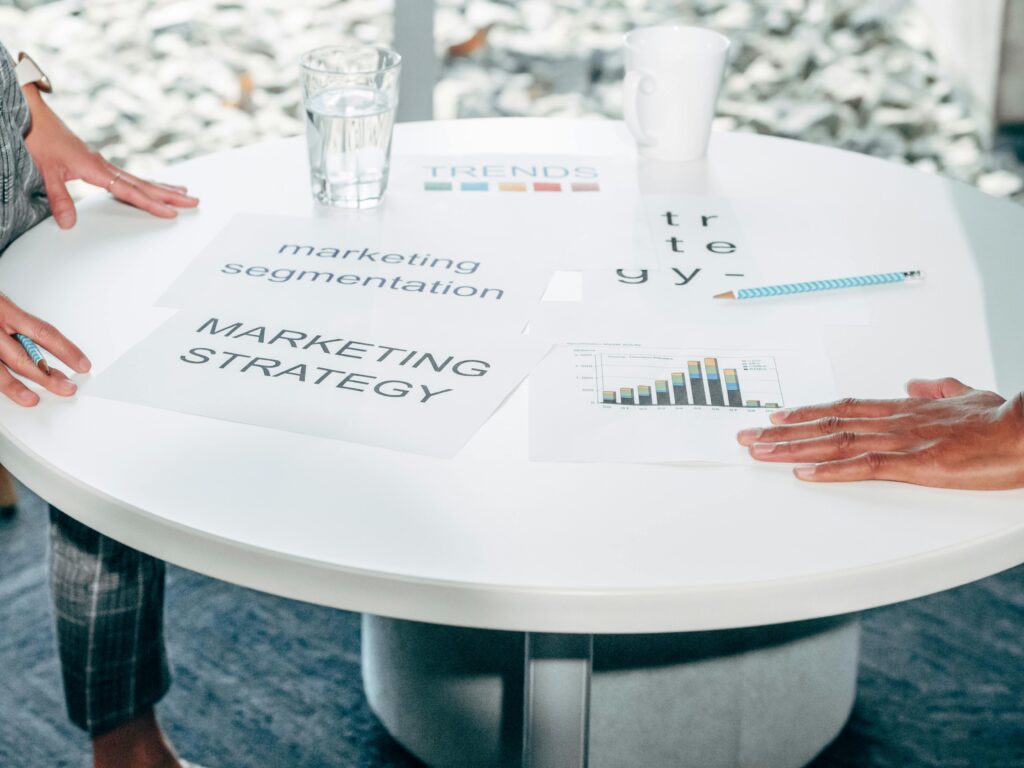 Pourquoi étudier le management est un avantage pour votre avenir professionnel ? Two professionals collaborate on marketing strategy and segmentation at a round table.